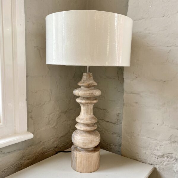 An oversized solid wood turned lamp with a white wash finish, complimented by a white linen shade. H73 x Dia 40cm
